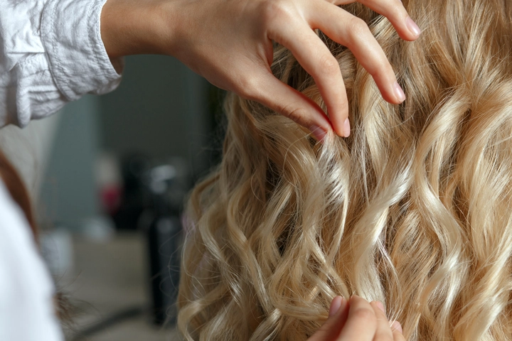 hairdresser hands touching beautiful clients curls after styling beauty salon closeup shot